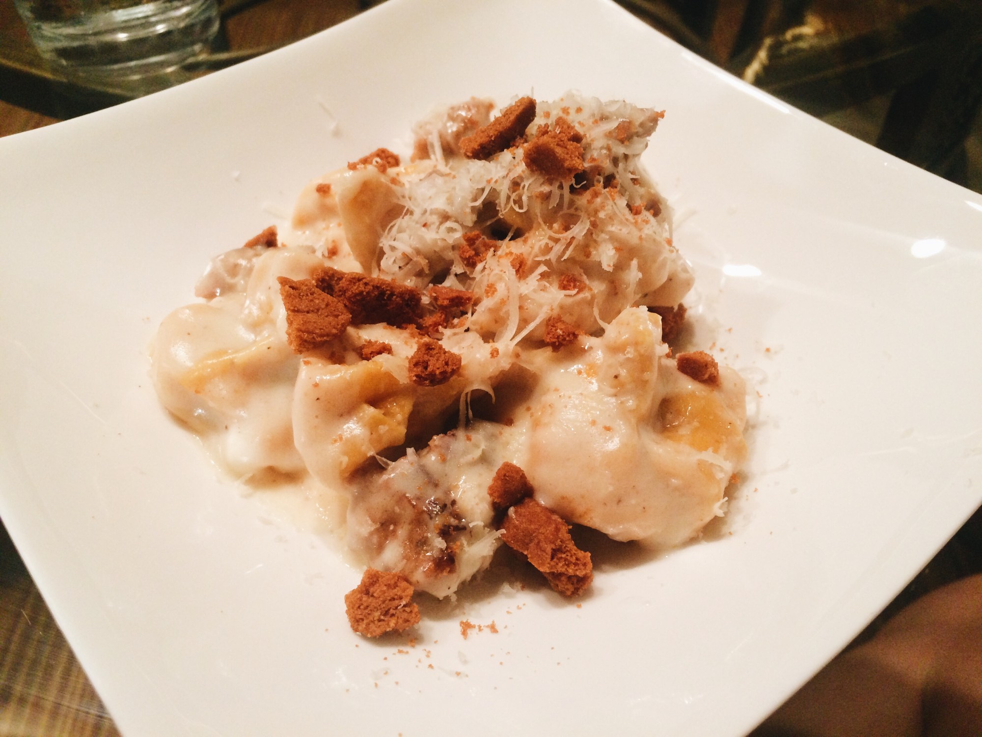 Pumpkin Sacchetti Pasta with crumbled sausage and a bechamel sauce with crumbled amaretti