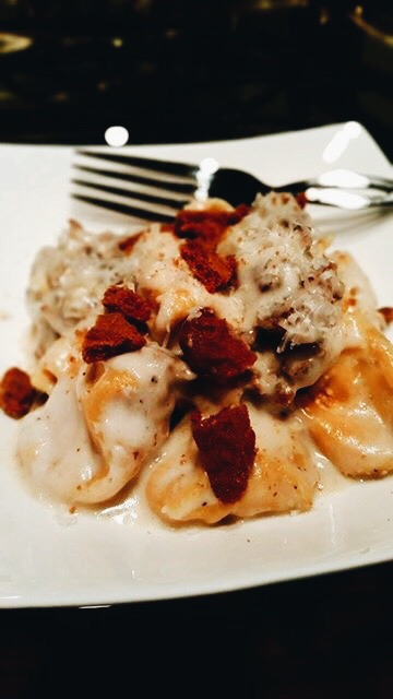 Pumpkin Sacchetti Pasta with crumbled sausage and a bechamel sauce with crumbled amaretti